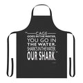 Jaws inspired apron with graphic design of a shark silhouette swimming in the water
