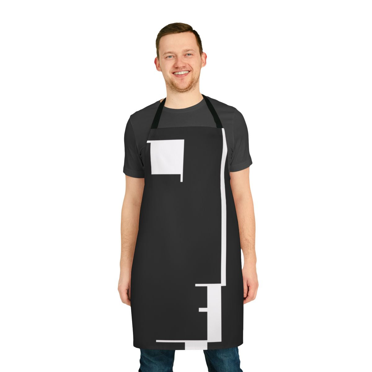 A black and white apron featuring a minimalist Bauhaus-inspired design with a face profile and geometric shapes.