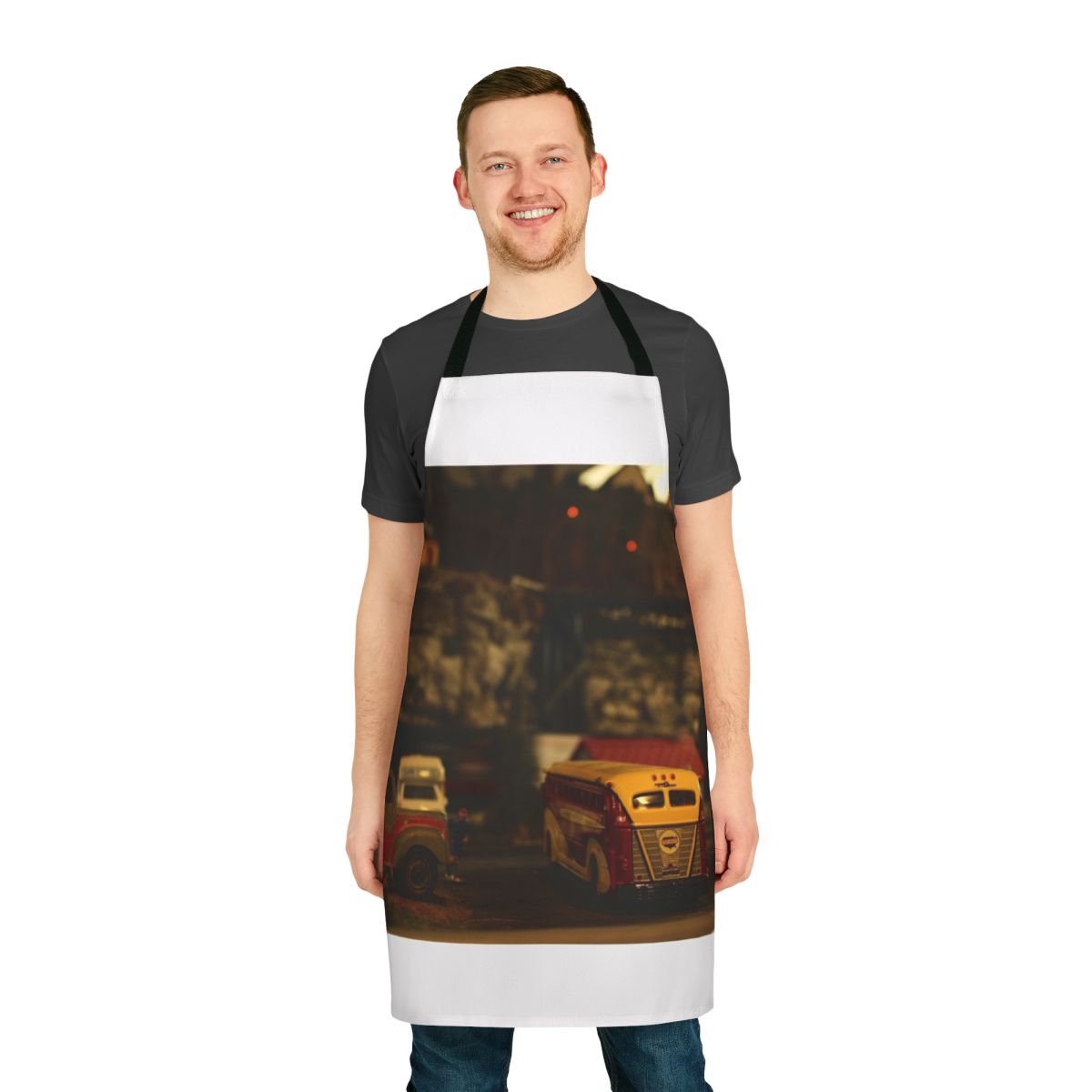 Person wearing a navy blue apron with a model train design
