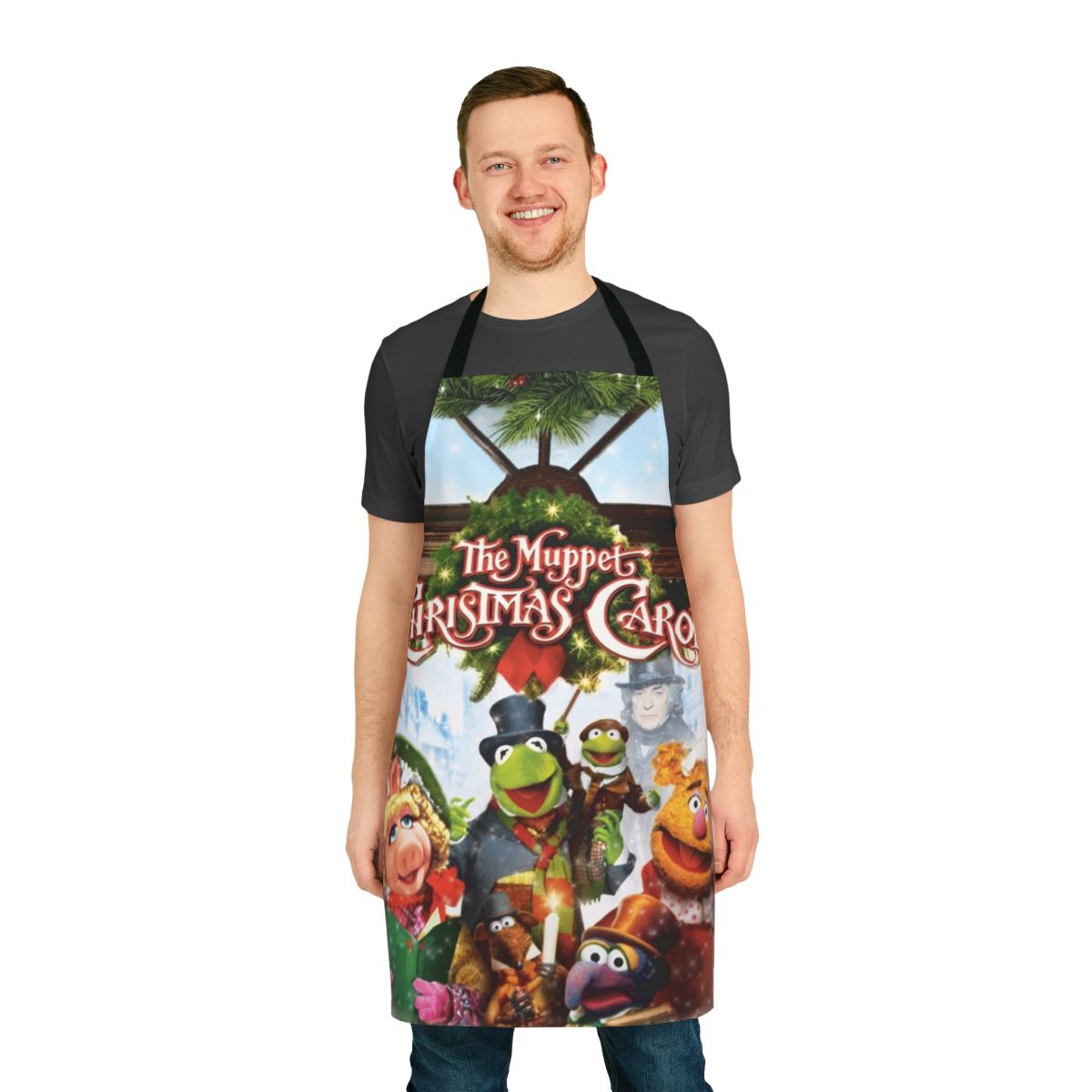 A red apron featuring characters from the Muppet Christmas Carol movie, including Kermit the Frog and Miss Piggy.
