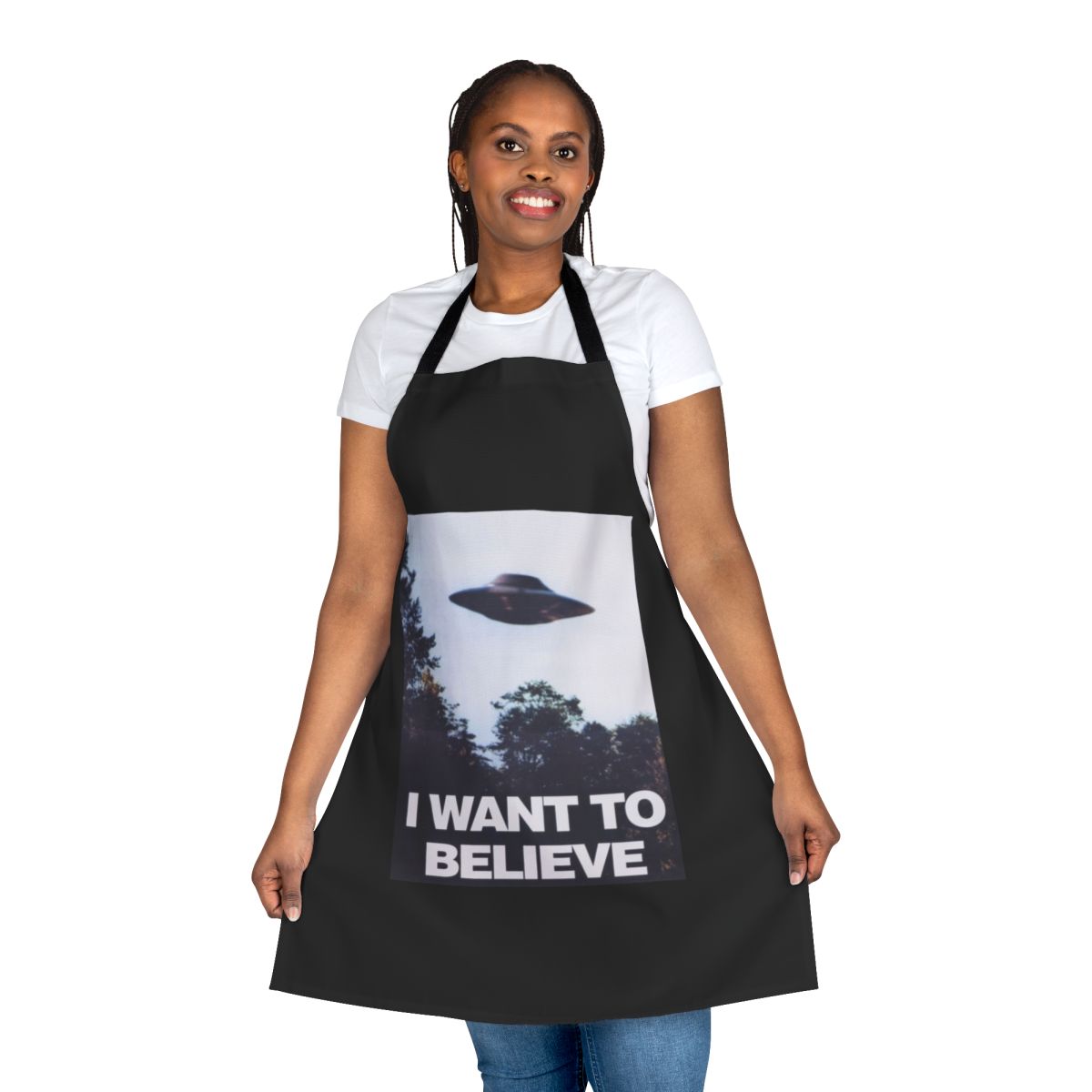 A black apron with an "I Want to Believe" graphic, featuring spooky elements like UFOs and aliens.