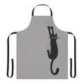 An illustration of a black cat clinging onto an apron with its sharp claws and an expression of determination on its face.