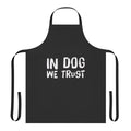 A black and white apron with the text "In Dog We Trust" printed on it, a fun and meaningful accessory for dog owners.