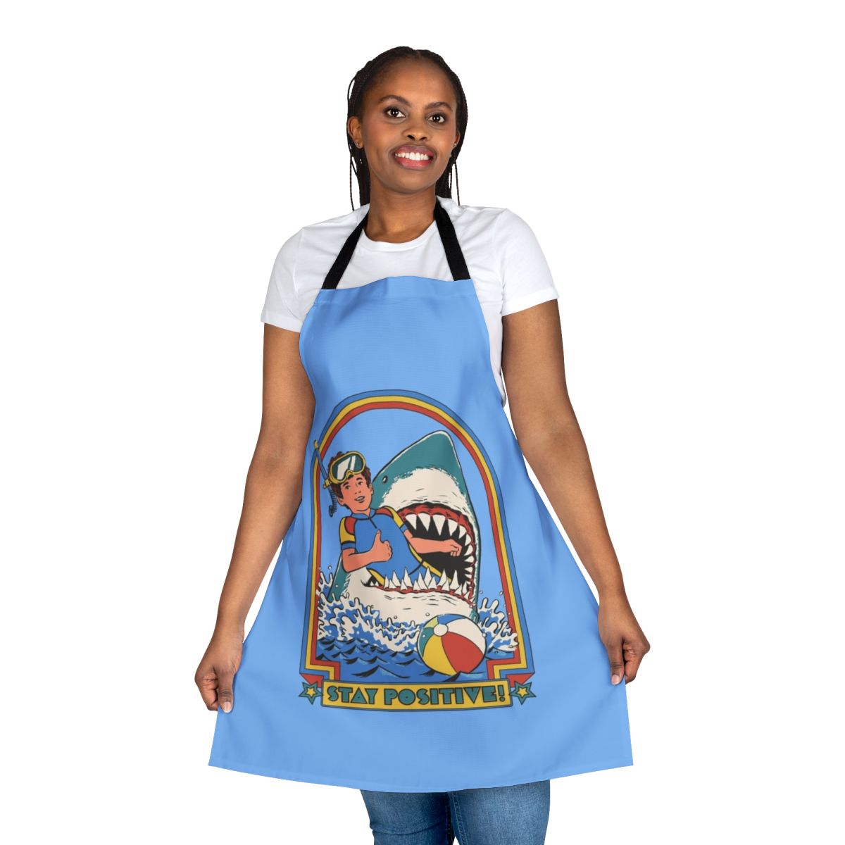 A white apron with a vintage-style illustration of a shark swimming in the ocean, with the text "Stay Positive" printed on it.