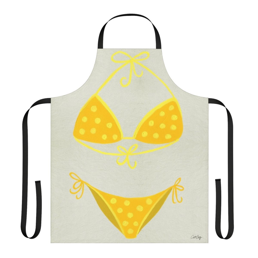 A cream-colored apron with a yellow polka dot pattern, inspired by classic swimsuit styles.