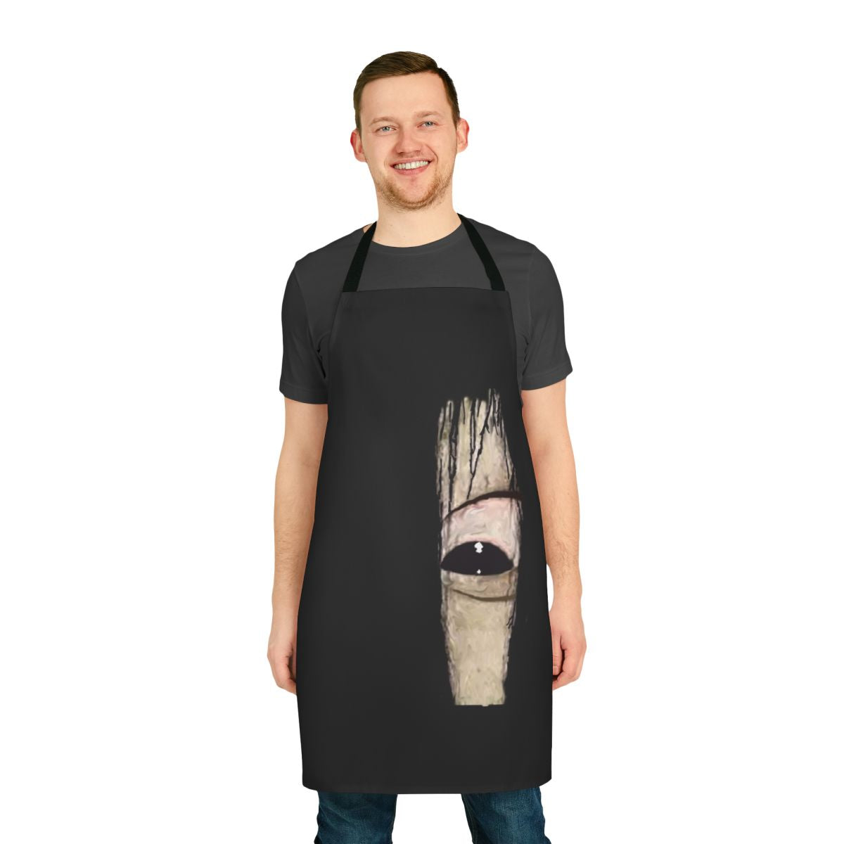 A black apron featuring an eerie close-up image of Sadako's eye, a classic horror movie icon.