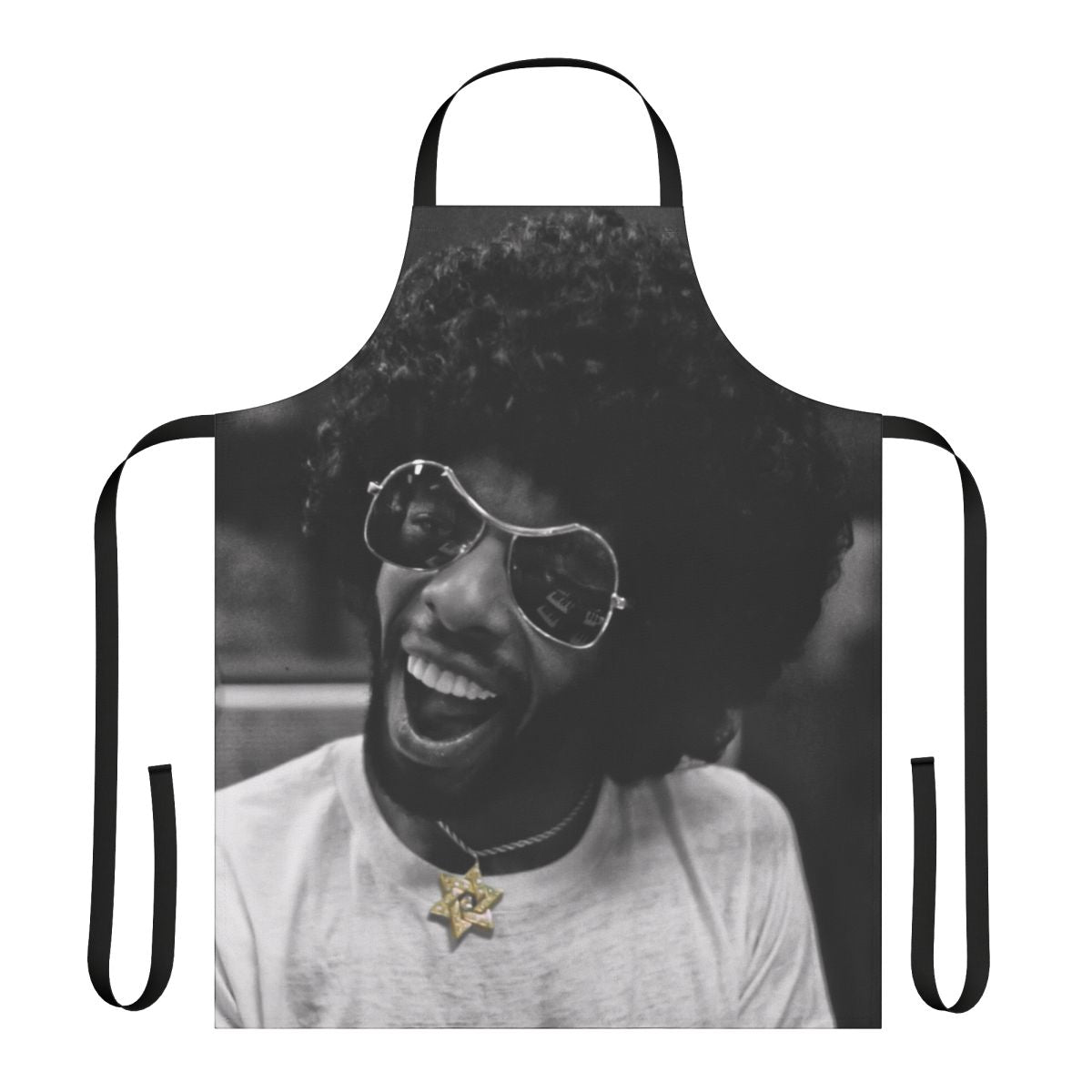 Black and white photo of a musician wearing a kitchen apron with a star of David and gold and diamond accents, in a recording studio.
