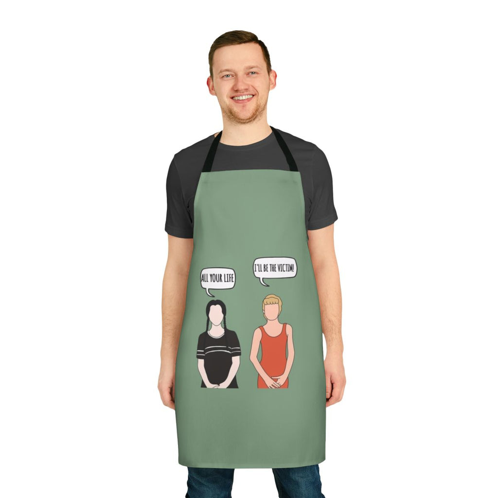 A black apron with a spooky "I'll Be the Victim" design, inspired by the Addams Family