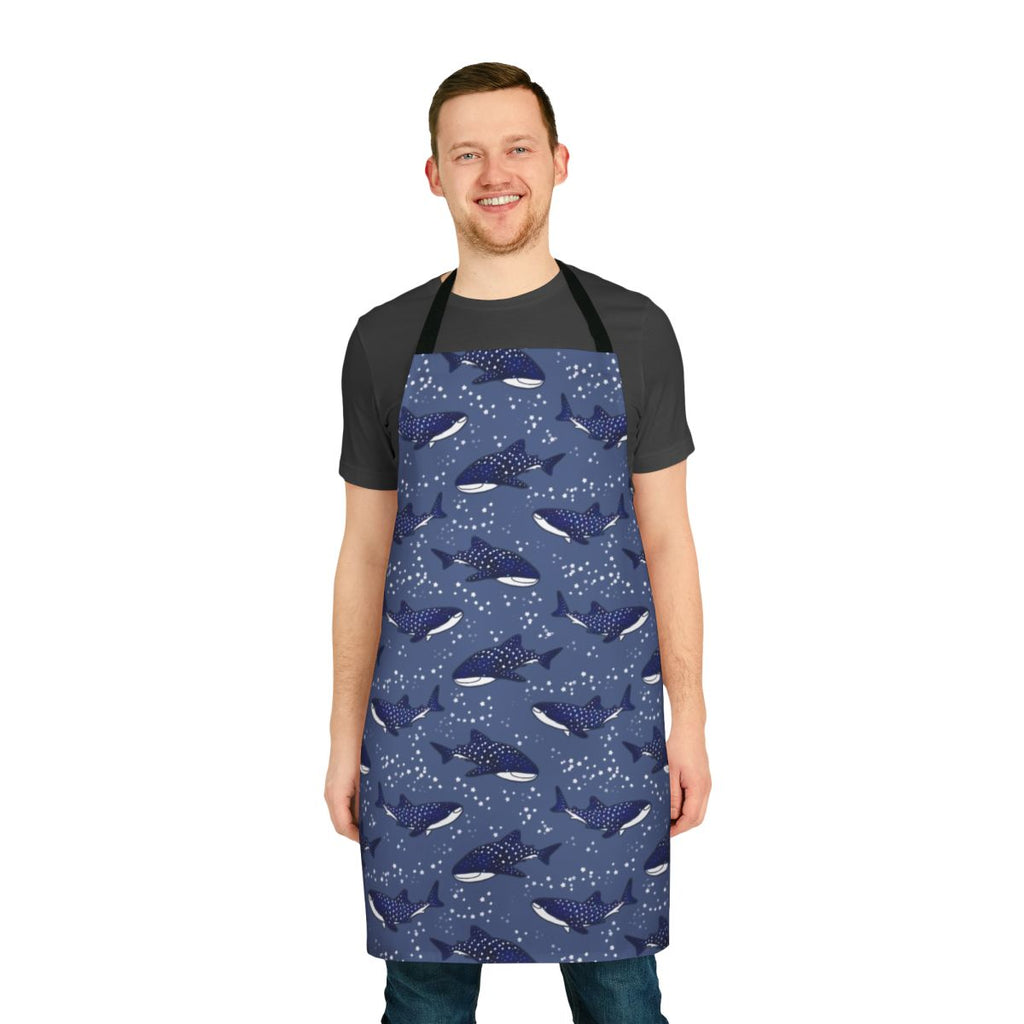 A dark blue apron featuring a starry night sky design with a cartoon whale shark