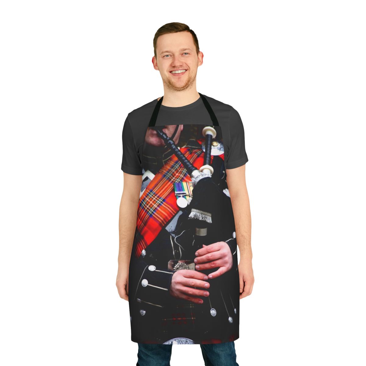 A red tartan apron with a bagpipe design, perfect for enjoying traditional Scottish music and culture.