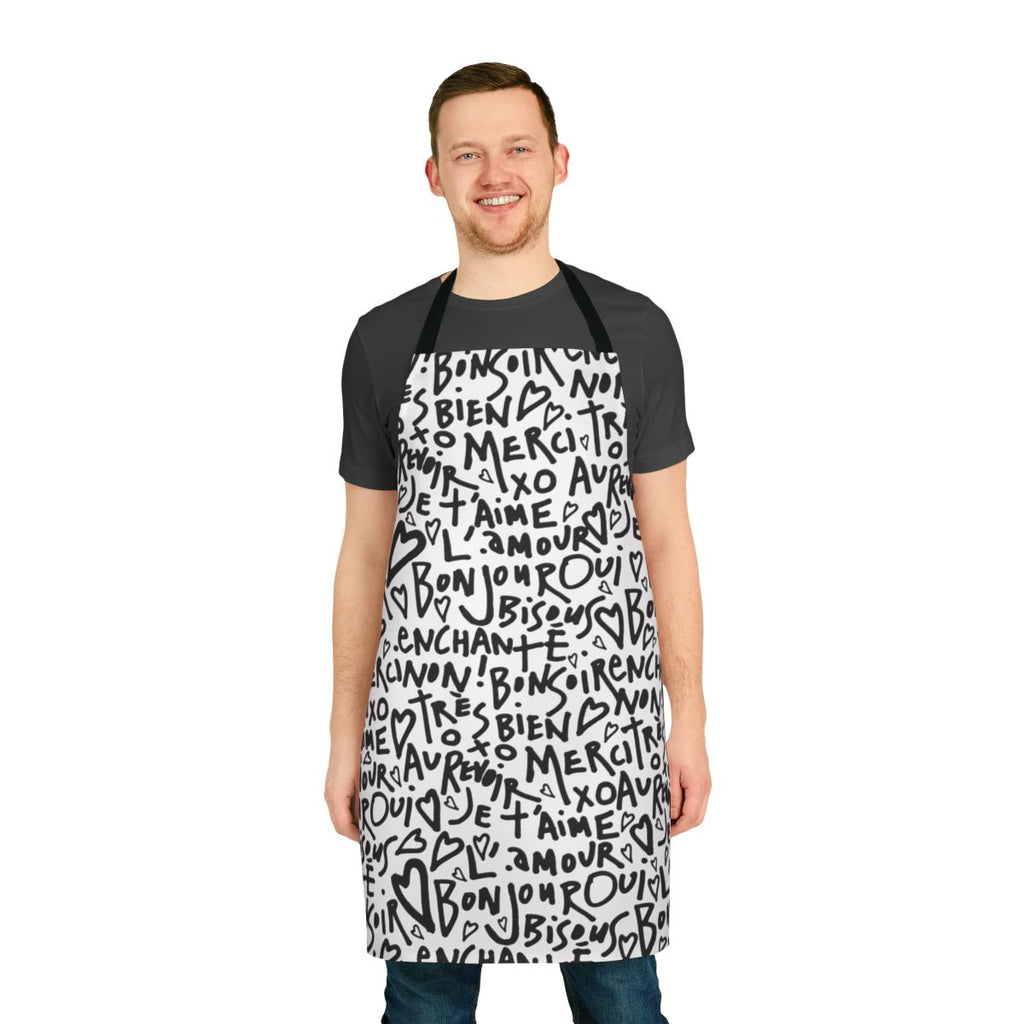 A white apron with a black hand-drawn design featuring the French phrase "I love you" and other French words and phrases.