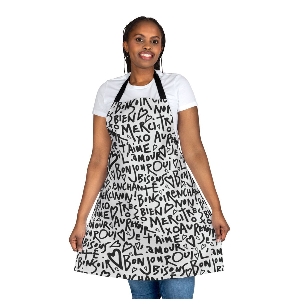 A white apron with a black hand-drawn design featuring the French phrase "I love you" and other French words and phrases.