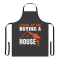 Man wearing a "Look at Me Buying a House" themed apron in his kitchen