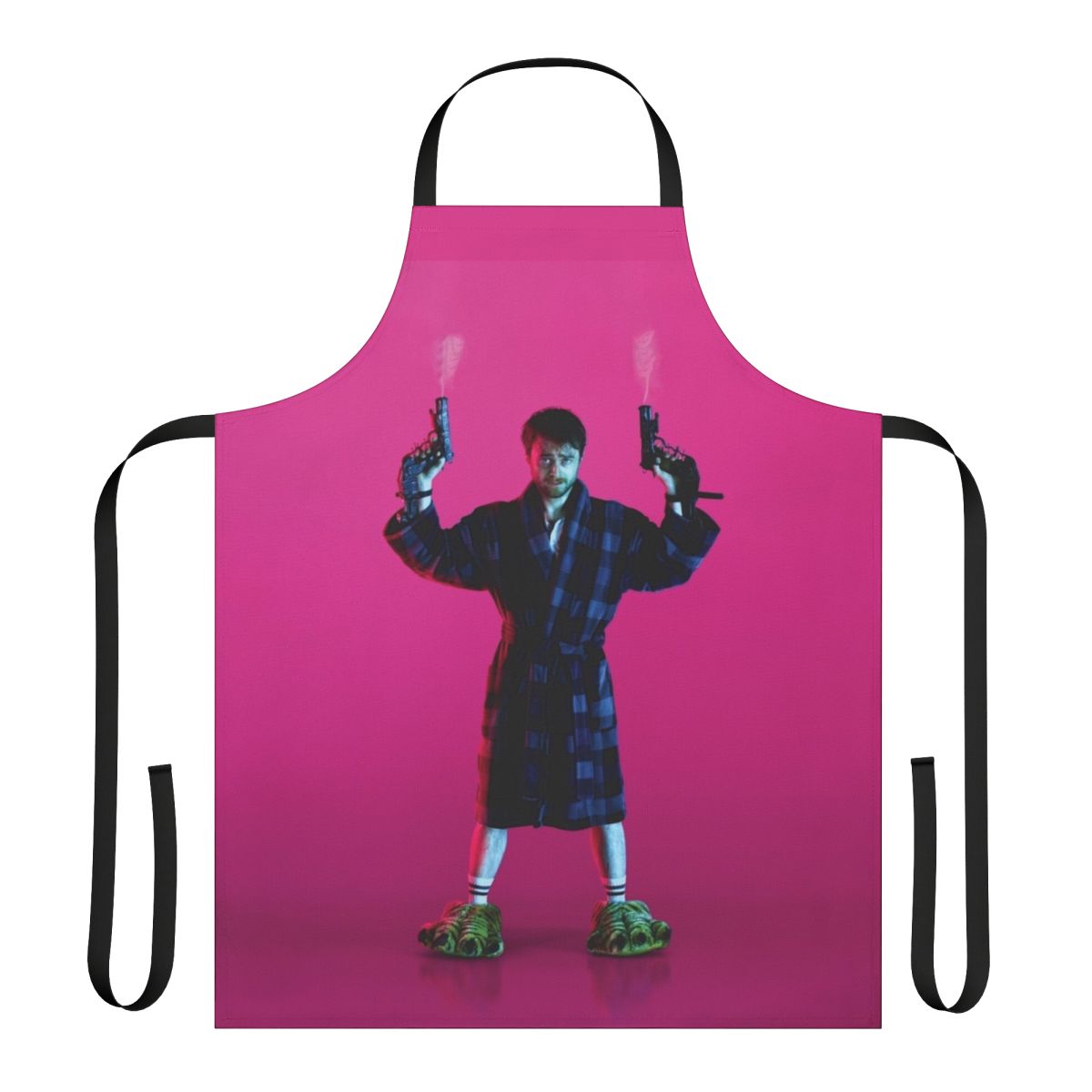 Pink apron with the text "Guns Akimbo" and a gun graphic, inspired by the movie starring Daniel Radcliffe.