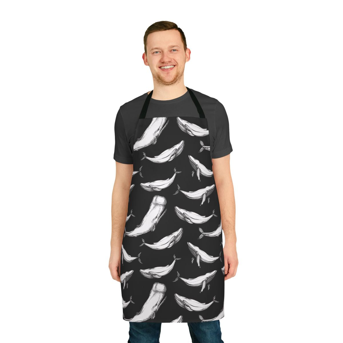 Black and white apron with a seamless repeating pattern of whales, including whale tails, flippers, and other oceanic details.