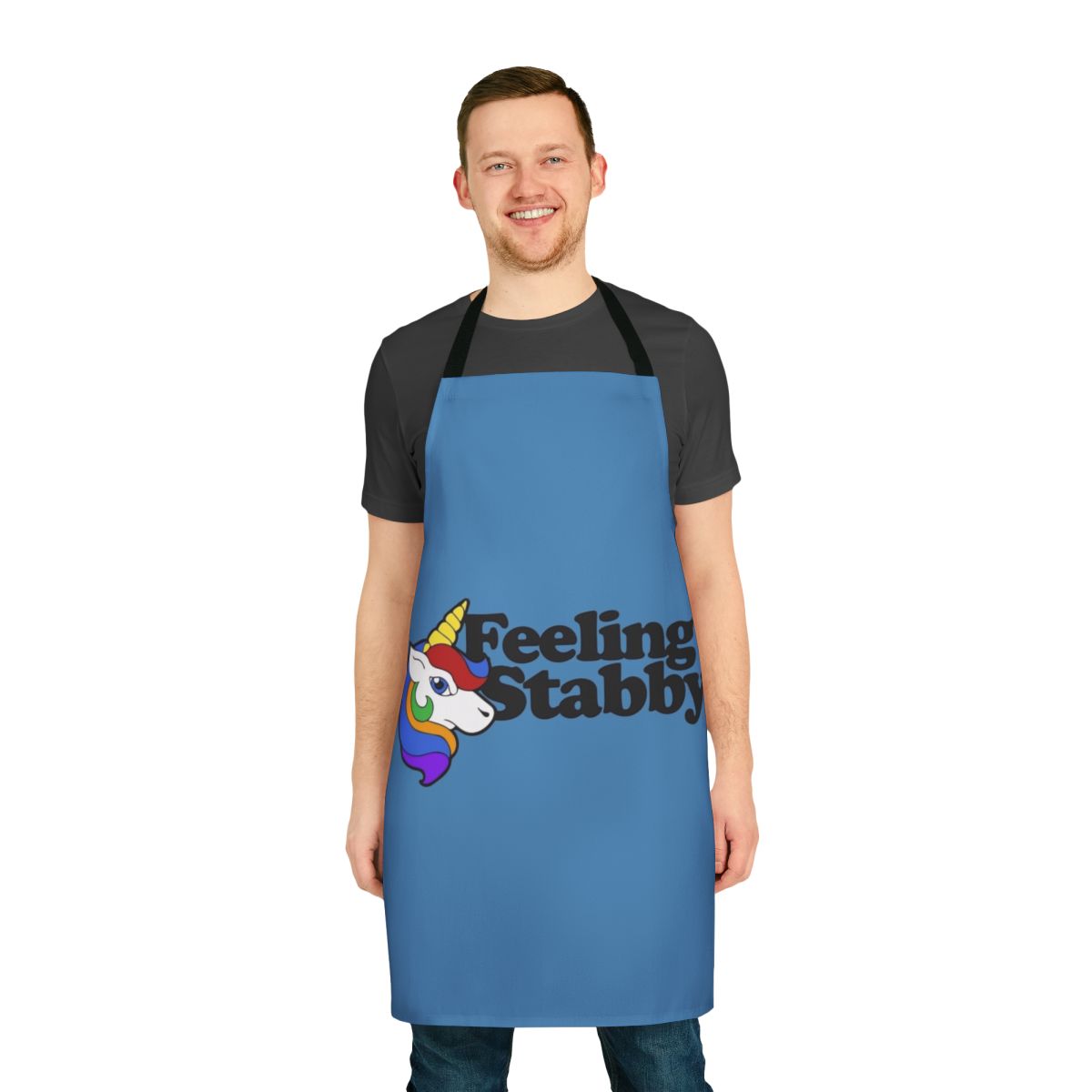 A white apron with a "Feeling Stabby" unicorn design, a humorous and quirky kitchen accessory.