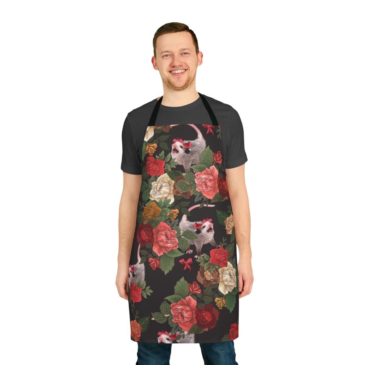 A pink and red floral apron with a repeating opossum or possum print, perfect for adding a touch of whimsy to your kitchen.