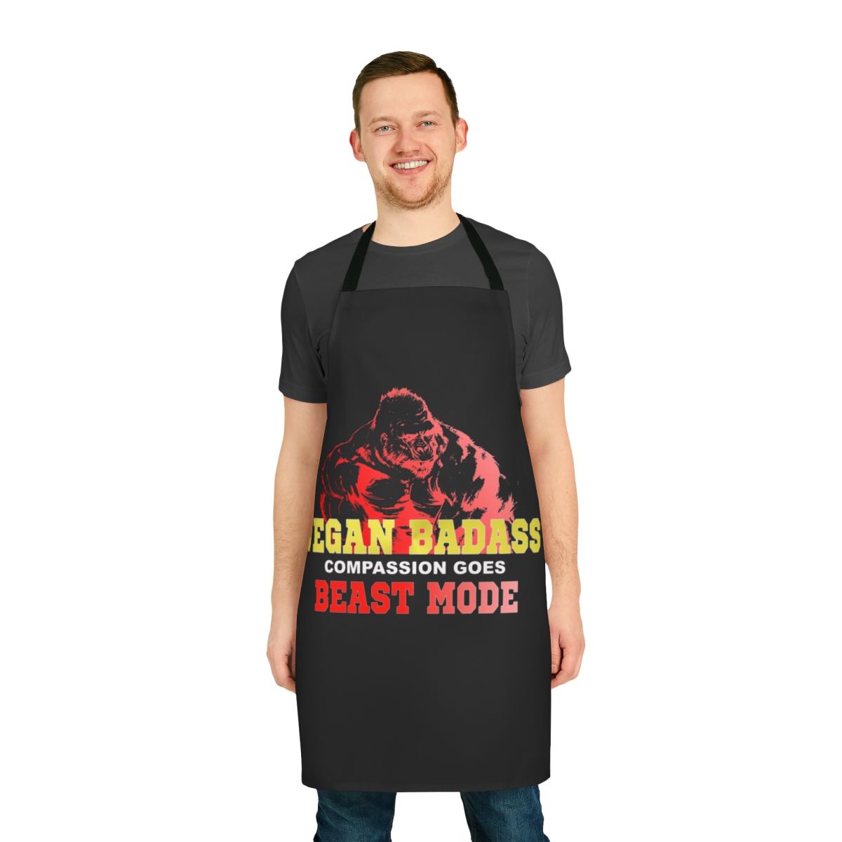 Vegan bodybuilder wearing a black apron with the text "Vegan Gorilla Badass Bodybuilder" printed on it.