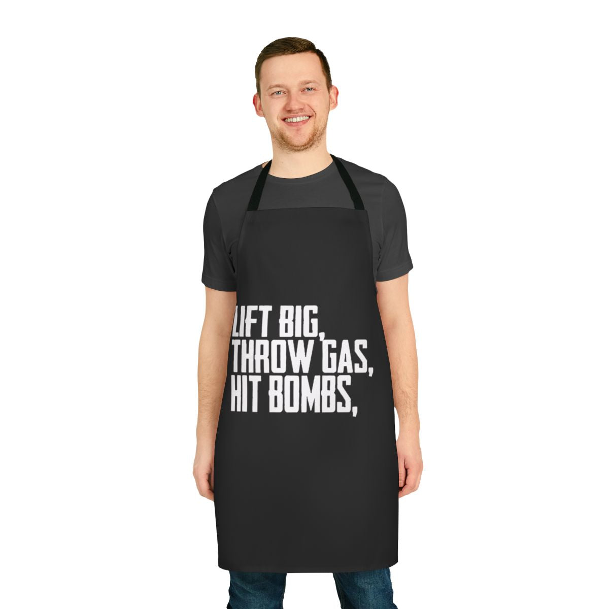 A black apron with a graphic design featuring the text "Lift Big Throw Gas Hit Bombs"