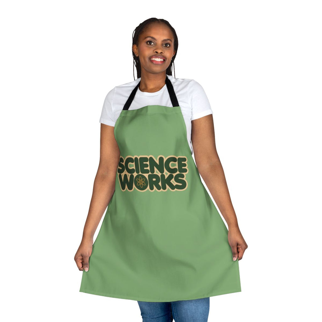 Person wearing a white science-themed apron with various scientific icons and designs