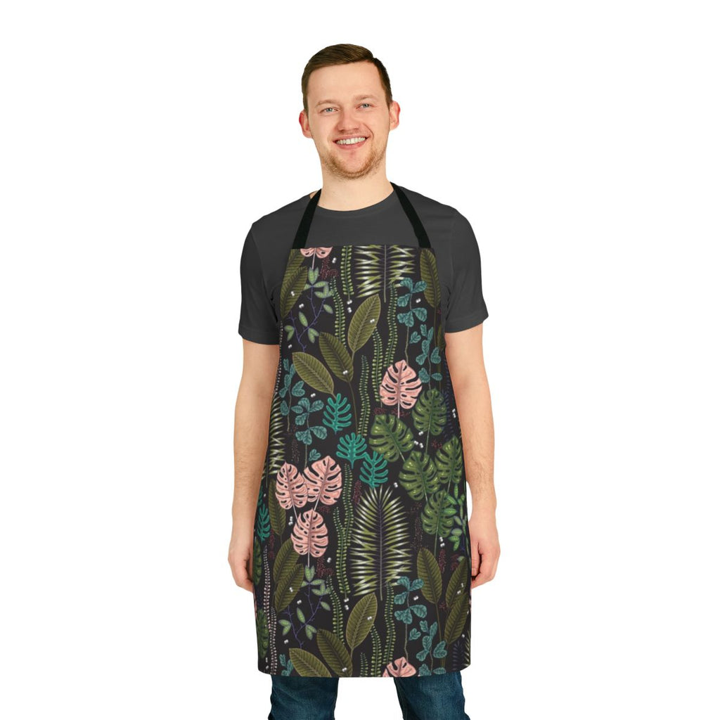 Lush, tropical-inspired apron featuring monstera leaves, palm fronds, and a blend of green, pink, and black