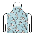 A blue and grey watercolor apron featuring a pattern of flying swallows against a cloudy sky.