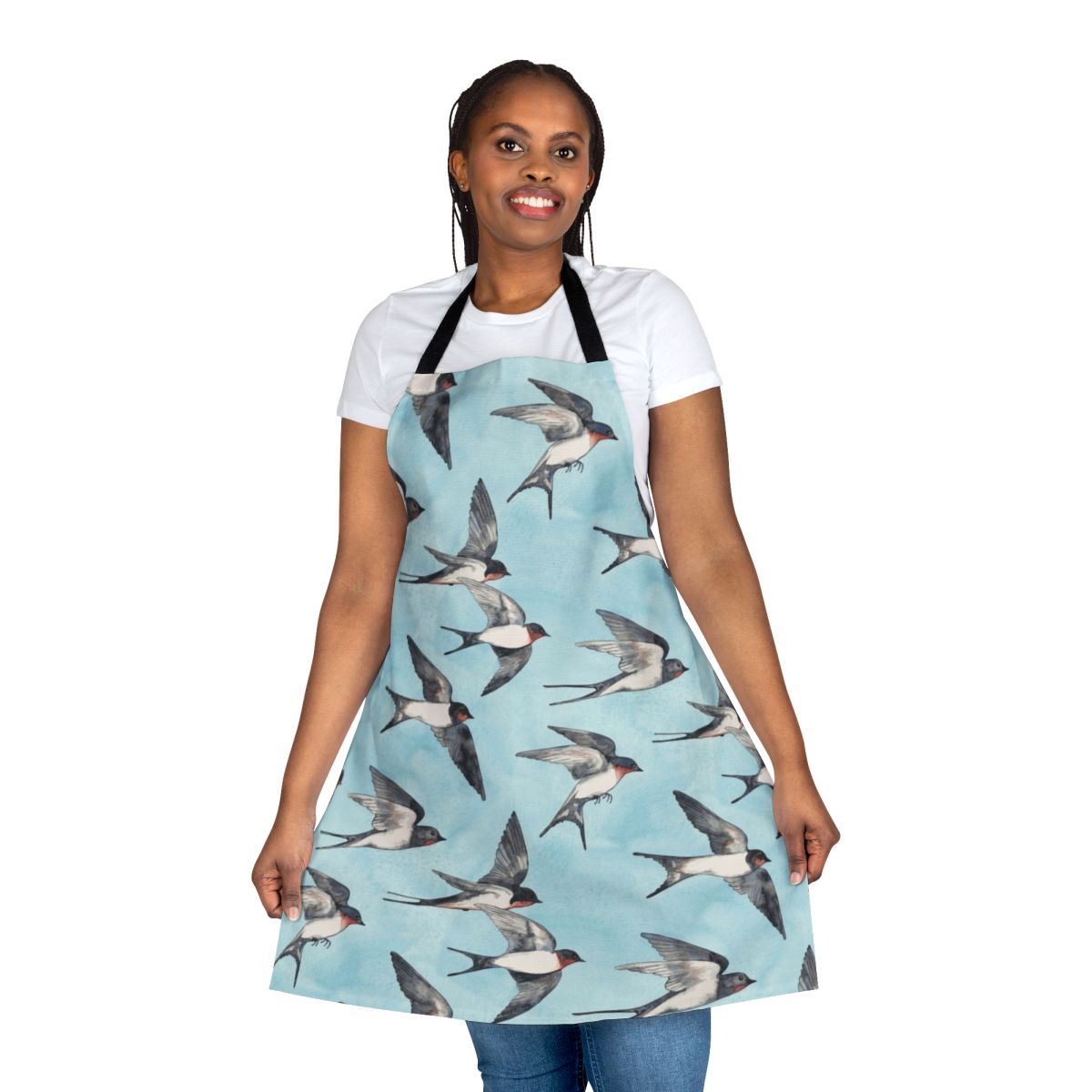 A blue and grey watercolor apron featuring a pattern of flying swallows against a cloudy sky.
