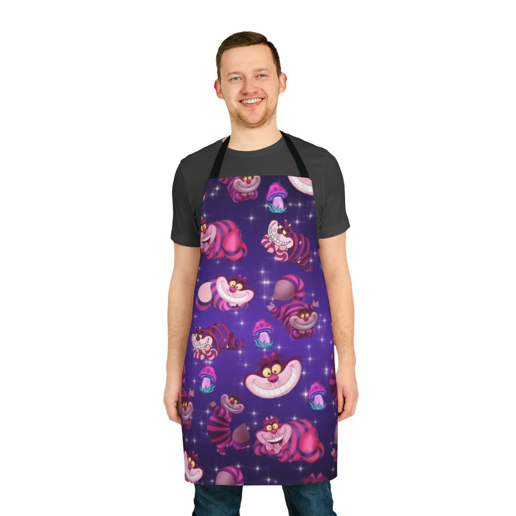 A colorful apron featuring a whimsical Alice in Wonderland-inspired design with a cat, mushrooms, and the Cheshire Cat.