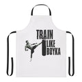 Person wearing a black apron with the text "Train Like Boyka" printed on it